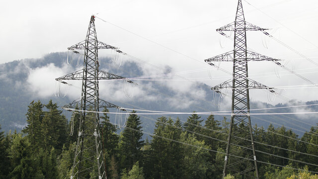 Hochspannungsmaste Zwei Hochspannungsmaste mit grünem Wald und Nebel im Hintergrund