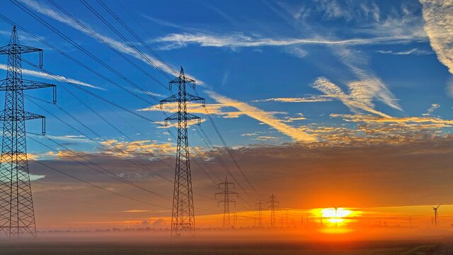 Freileitungsmaste bei Sonnenaufgang - für eine sichere und zuverlässige Energieversorgung