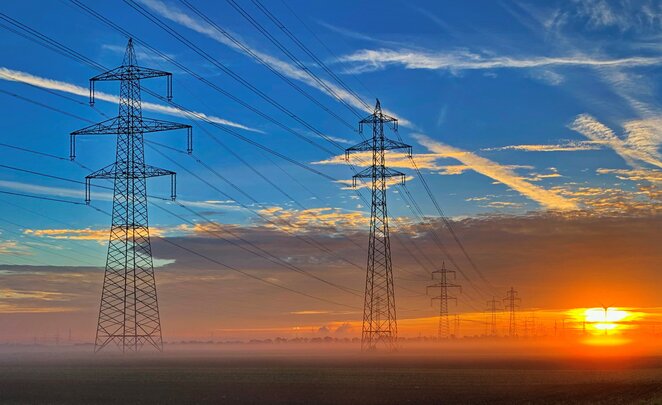 Freileitungsinfrastuktur Freileitungsmaste bei Sonnenaufgang - für eine sichere und zuverlässige Energieversorgung