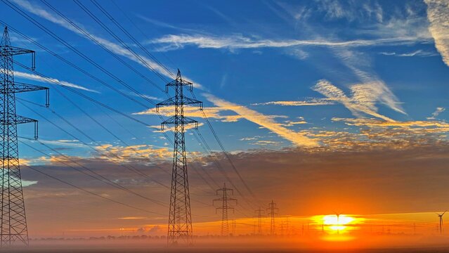 Freileitungsinfrastuktur Freileitungsmaste bei Sonnenaufgang - für eine sichere und zuverlässige Energieversorgung