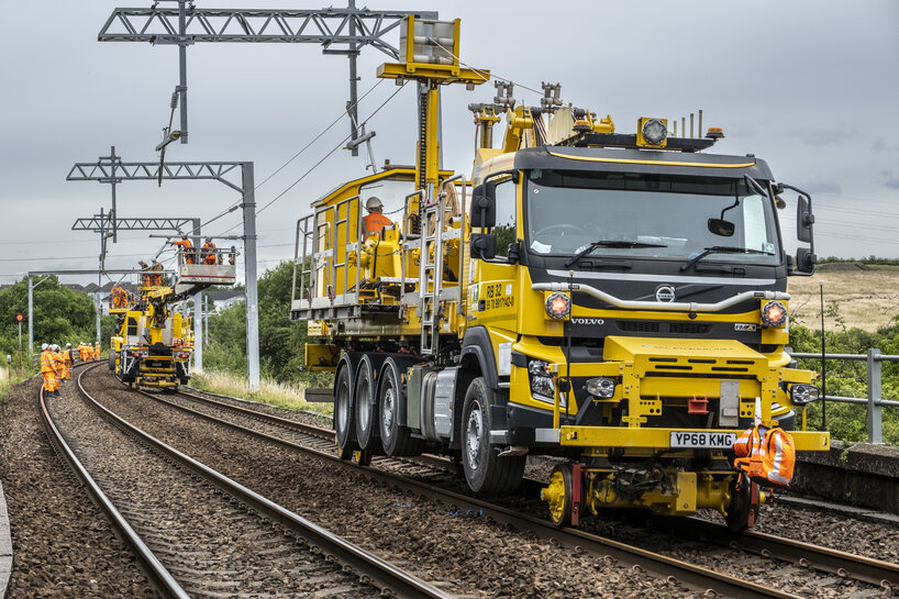 Monteure führen mit Hilfe von zwei Maschinen Oberleitungsarbeiten durch.