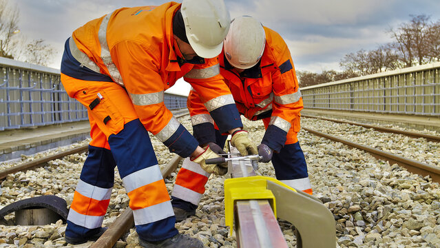 Montagearbeiten an der dritten Schiene Zwei Monteure arbeiten an der dritten Schiene im Nahverkehr/U-Bahn