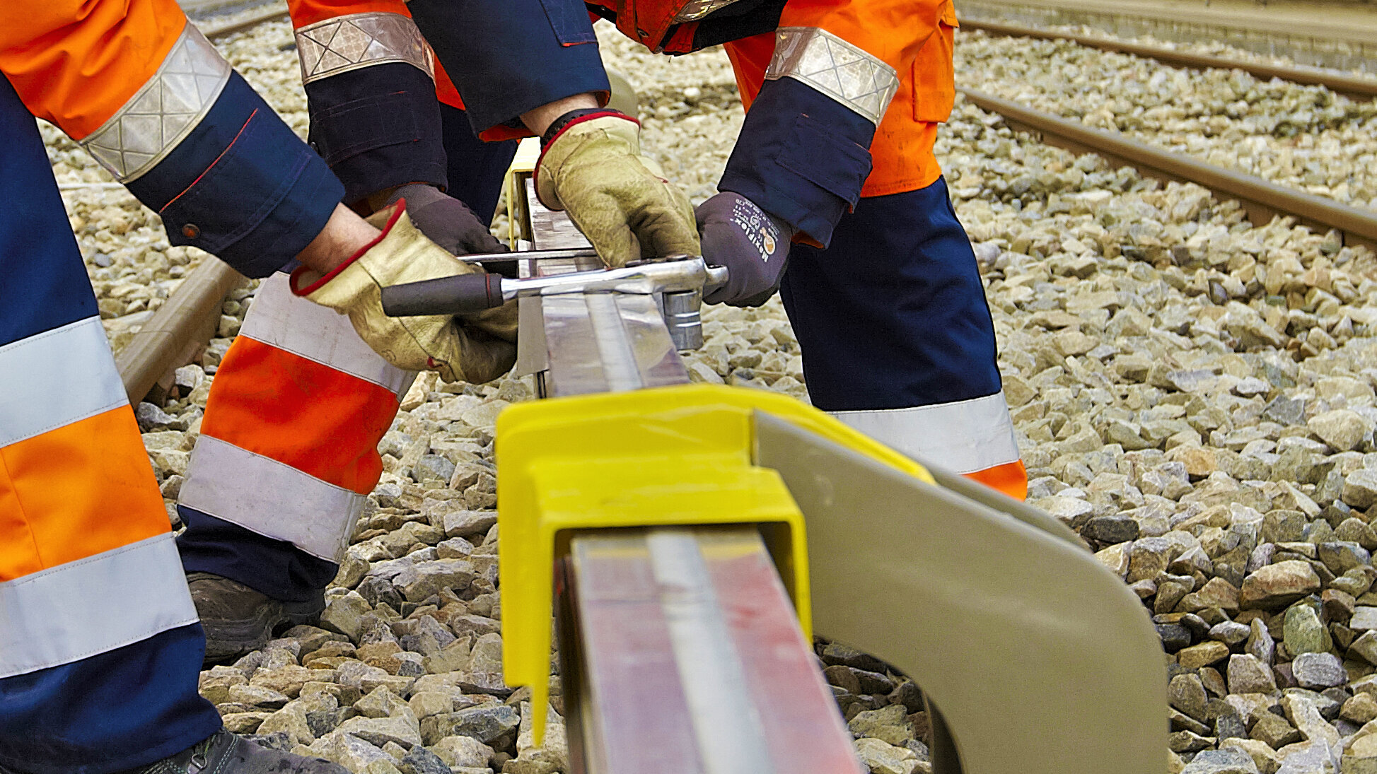Zwei Monteure arbeiten an der dritten Schiene im Nahverkehr/U-Bahn