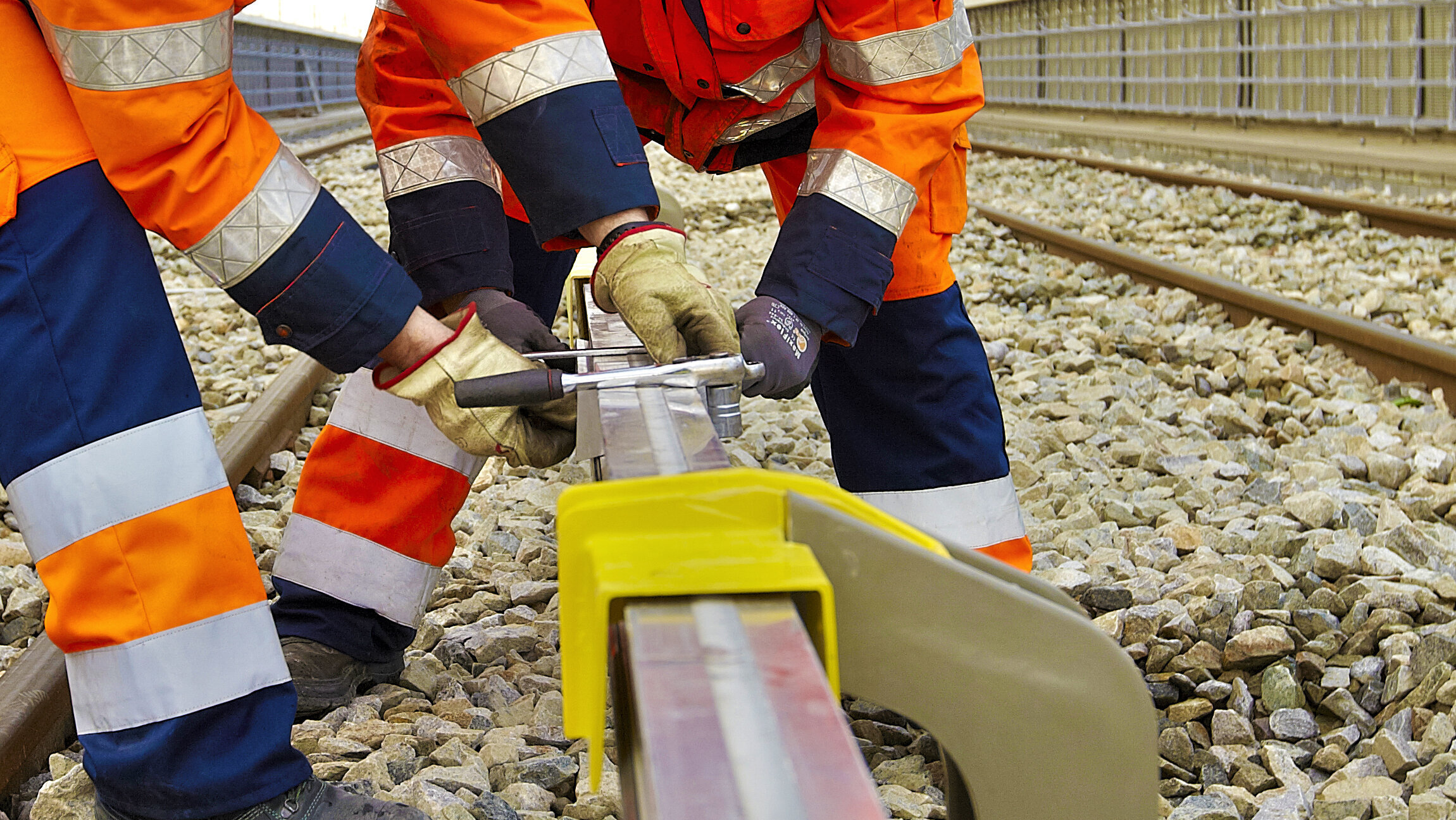 Zwei Monteure arbeiten an der dritten Schiene im Nahverkehr/U-Bahn